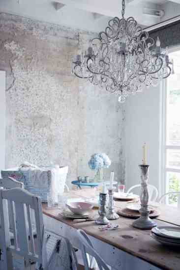 A whitewashed cement wall makes an amazing backdrop for a crystal chandelier.